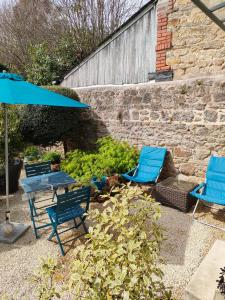 two blue chairs and a table with an umbrella at La Suite 27 bis, duplex indépendant in Guingamp
