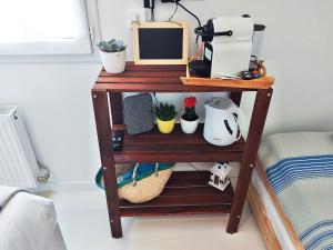 a wooden shelf with a computer and plants on it at Dream of Mediterranean house, Jacuzzi, BBQ, Délices ensoleillés in Sartrouville