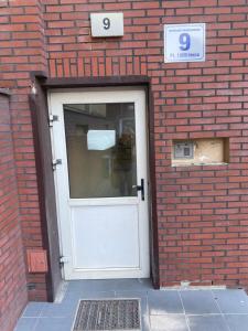 a door in a brick building with the number six at Turkusowy Zakątek Głogów in Głogów