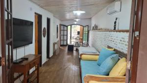 un soggiorno con divano blu e TV di Casa Paúba 80m do Mar a Maresias
