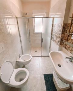 a bathroom with a toilet and a sink and a shower at Cozy and spacious two bedroom apartment in Shengjin in Shëngjin