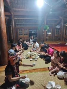 a group of people sitting around a table eating food at Xuân nghi homestay in Yen Bai