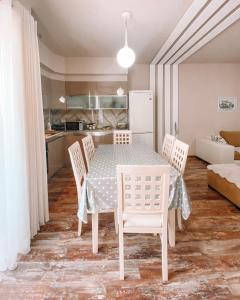 a kitchen and dining room with a table and chairs at Cozy and spacious two bedroom apartment in Shengjin in Shëngjin