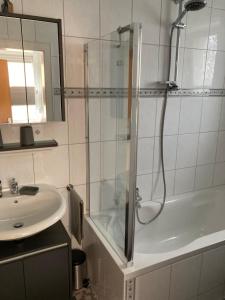 a bathroom with a shower and a sink and a tub at Ferienhaus Gartenblick in Brieden in Brieden +37 photos