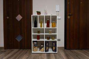 a white book shelf with different types of food at Zio Michele's house in Pimonte