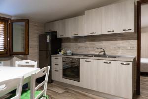 a kitchen with white cabinets and a sink and a table at Zio Michele's house in Pimonte