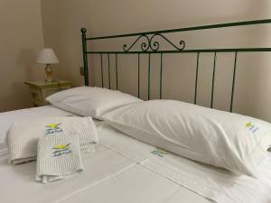 a bed with white sheets and towels on it at Affittacamere Bellavista in San Marco dei Cavoti