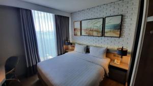 a hotel room with a bed and a window at Expressia Hotel Makassar in Makassar
