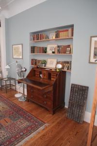 Rosie's Place: Furnished Apartment with Style في فاينهايم: مكتب مع مكتب و رف كتاب مع كتب