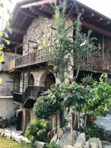 San Damiano Macra的住宿－Ca' di Nobi Podio Val Maira，一座石头建筑,设有阳台,前面有树木