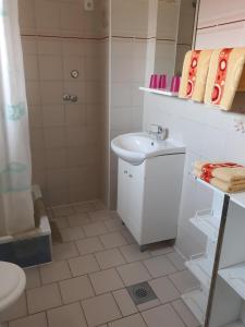 biała łazienka z umywalką i prysznicem w obiekcie Apartmani Marija i Josip w mieście Vir