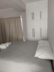 a bedroom with a bed with white cabinets at Alexandra's Apartments - Port of Zante in Zakynthos