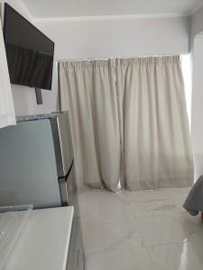 a kitchen with a refrigerator and a window at Alexandra's Apartments - Port of Zante in Zakynthos