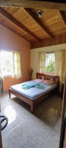 a large bed in a room with two windows at Hostel Matilori in Sámara