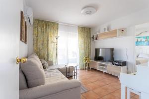 uma sala de estar com um sofá e uma televisão em Cozy apartment in the center of Benidorm! em Benidorm