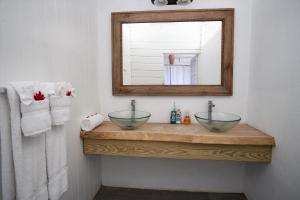 a bathroom with two bowl sinks and a mirror at Fond Doux Eco Resort in Soufrière