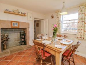 a dining room with a table and a fireplace at Hill Cottage in Matlock +18 photos