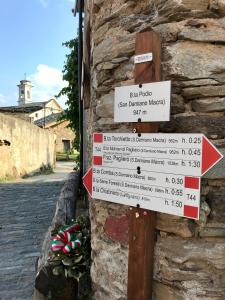 ein Schild an der Seite einer Steinmauer in der Unterkunft Ca' di Nobi Podio Val Maira in San Damiano Macra