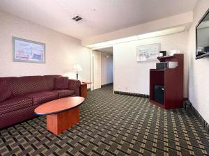 a living room with a couch and a table in a hotel room at Ramada by Wyndham South El Monte in South El Monte