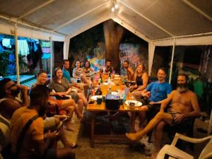 een groep mensen die rond een tafel zitten bij Hostel Matilori in Sámara
