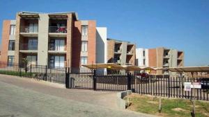 a building with a fence in front of it at Luxuries Penthouse in Nelspruit