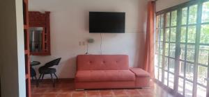 sala de estar con sofá rojo y TV en Villas Amalia Hotel en Sayulita