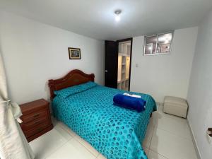 a bedroom with a bed with a blue comforter at Apartamento amoblado para alquiler temporal zona Norte in Pasto
