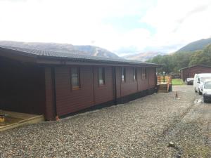 un bâtiment avec une voiture garée devant lui dans l'établissement Rowardennan Hotel, à Rowardennan