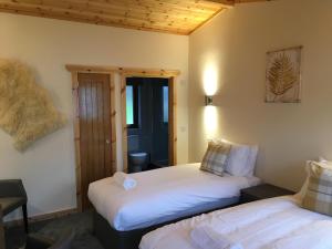 a bedroom with two beds and a door to a room at Rowardennan Hotel in Rowardennan