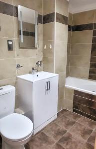 a bathroom with a toilet and a sink and a tub at Stunning 2 bedroom apartment in Canary Wharf - Morland Apartments in London