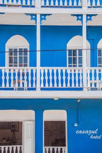 ein blaues Gebäude mit weißen Fenstern und einem Balkon in der Unterkunft Hotel Casazul in Flores