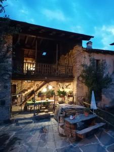 eine Außenterrasse mit einem Tisch und einem Balkon in der Unterkunft Ca' di Nobi Podio Val Maira in San Damiano Macra