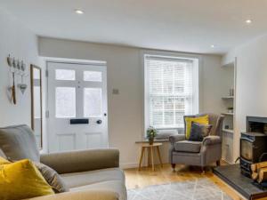 a living room with a couch and a chair and a door at The Cottage on Fairbank - Kirkby Lonsdale in Kirkby Lonsdale