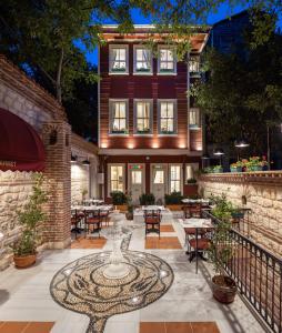 Un patio con mesas y sillas frente a un edificio. en Hotel Turkish House, en Estambul