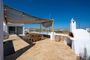 a patio with a table and chairs on top of a house at Little Villa amid Super Paradise-JackieO' Mykonos in Super Paradise Beach