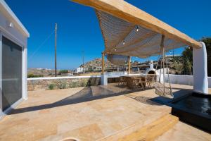 a patio with a table and a volleyball net at Little Villa amid Super Paradise-JackieO' Mykonos in Super Paradise Beach