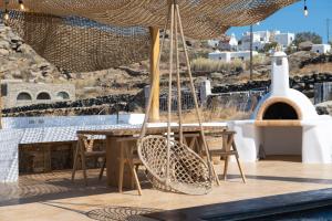 a patio with a table and chairs and an umbrella at Little Villa amid Super Paradise-JackieO' Mykonos in Super Paradise Beach