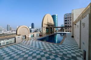 a swimming pool on top of a building with a city at Elite Tower in Seef