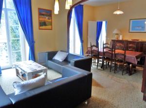 - un salon avec un canapé et une salle à manger dans l'établissement Vaste appartement, lumineux, 8 couchages, à Eaux-Bonnes