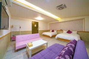 羅東鎮的住宿－哈妮的家，客厅配有两张床和一张紫色沙发