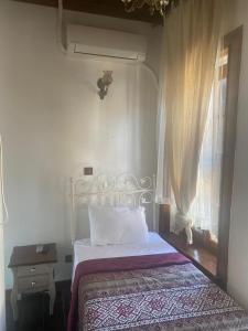 Schlafzimmer mit einem Bett und einem Fenster in der Unterkunft Aristonicus Boutique Hotel in Bergama