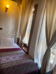 a bedroom with two beds and a window with curtains at Aristonicus Boutique Hotel in Bergama