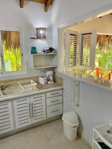 uma casa de banho branca com um lavatório e um WC em Villa tropical in private residence em Las Terrenas
