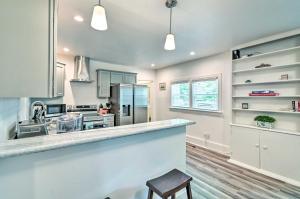 a kitchen with white cabinets and a counter with a stool at Pet-Friendly Fayetteville Home with Fenced Yard in Fayetteville
