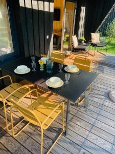 a black table and chairs on a deck at HJEM - Tiny Home in Bergatreute