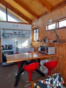 una cocina con una gran mesa de madera y sillas rojas en LOS CLAVELES, en Dichato