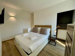 een slaapkamer met een bed met witte lakens en kussens bij La Petite Maison in Colombaro