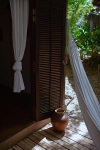 a vase sitting on the porch of a house at Quinta do Cajú in Ilha de Boipeba