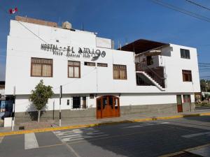un edificio blanco en la esquina de una calle en Hostal El Amigo, en Paracas
