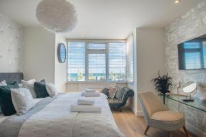 a bedroom with a large bed and a couch at The Beach Escapes in Hythe